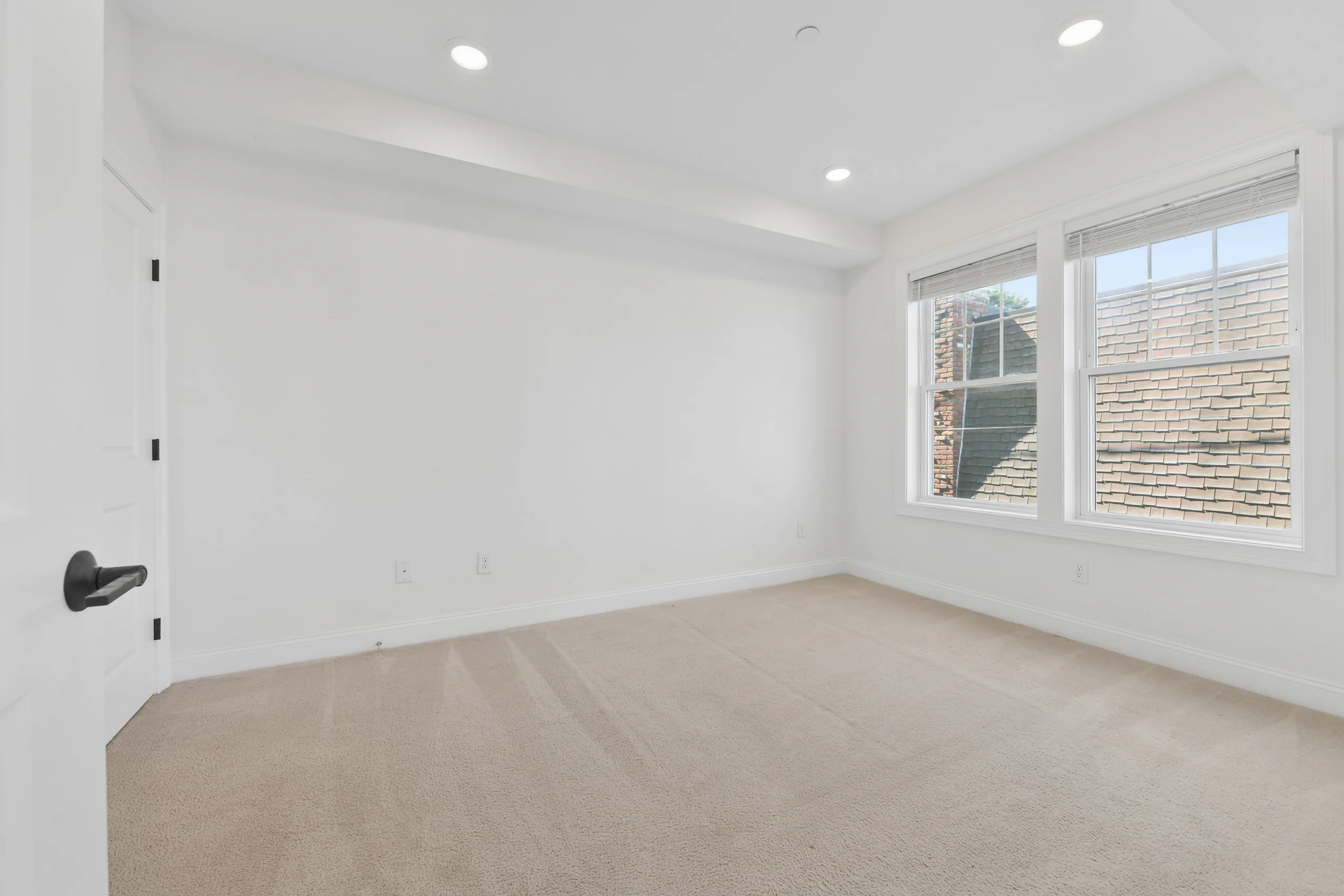 Carpeted bedroom with twin windows at 55 Monk St