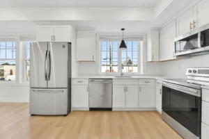 Kitchen with stainless steel appliances and white shaker cabinets at 55 Monk St