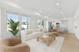 Virtually staged living room at 55 Monk St, Stoughton, with sofa, armchairs and open kitchen beyond