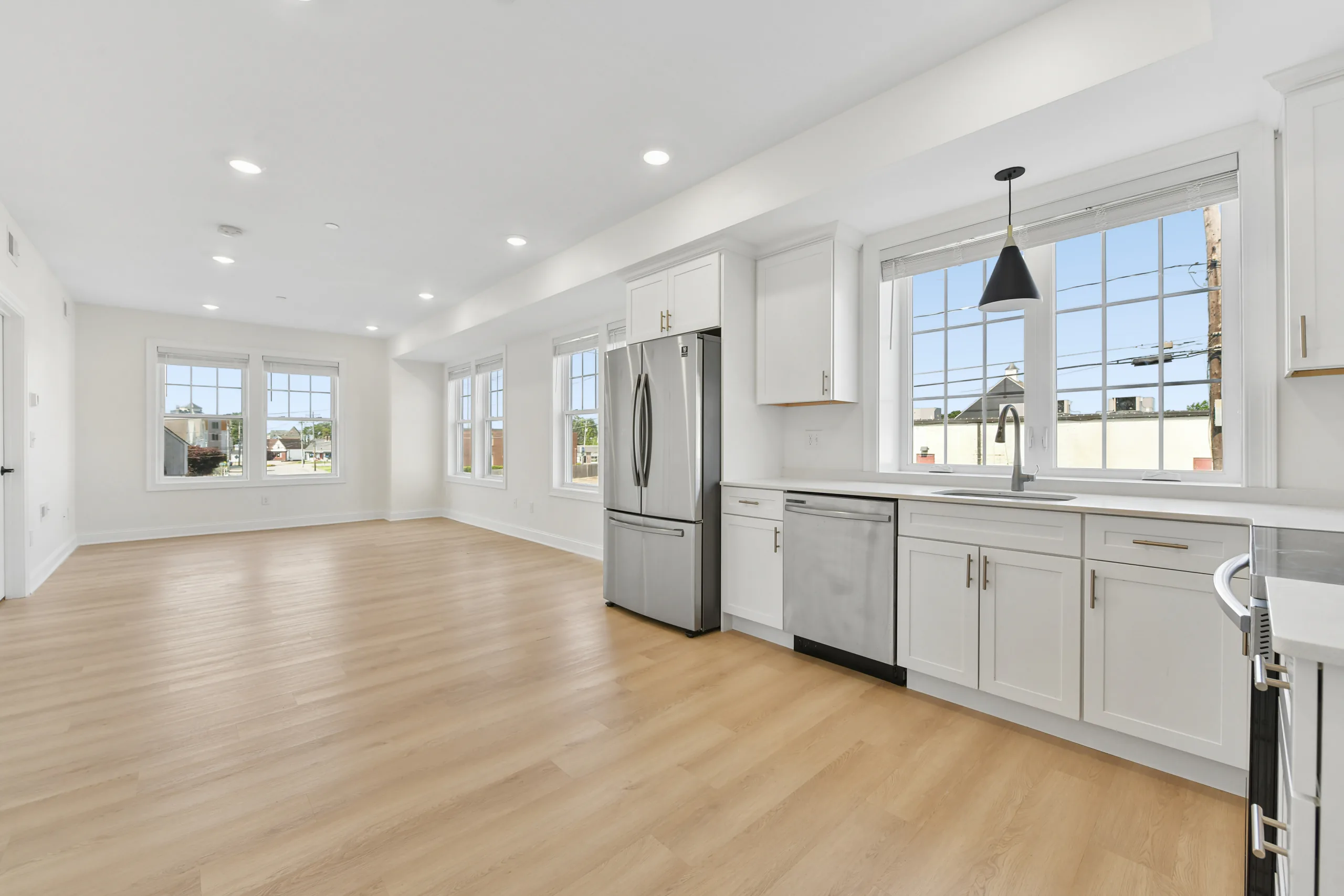 Open-plan kitchen and living area with hardwood floors at 55 Monk St